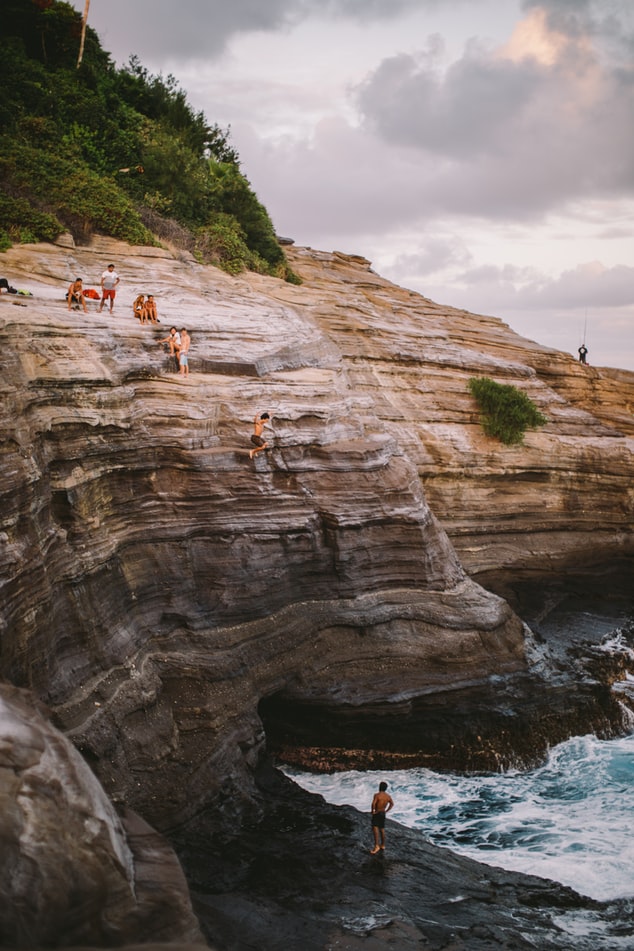 cliff jumping above the ocean, jumping in the sea, 20 trips to take in your 20s