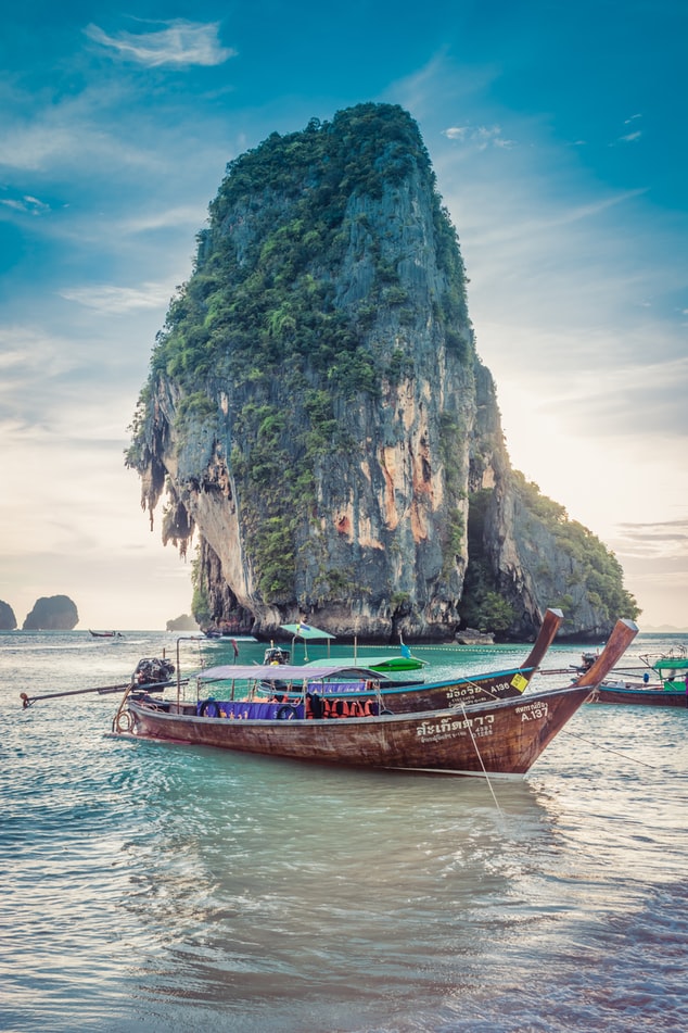 ocean with a boat and mountain in the background in thailand
