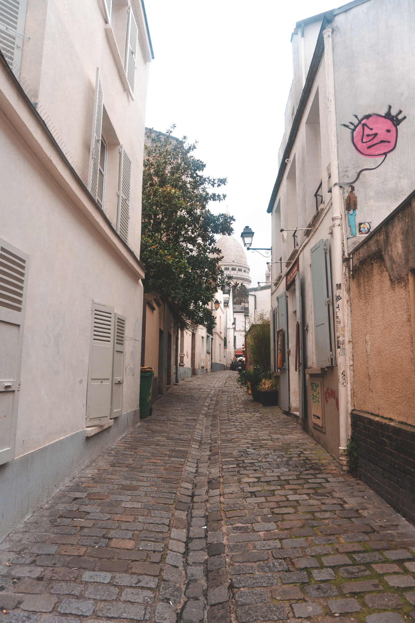 back street in montmartre with the sacre coeur in the background, paris guide, montmartre guide