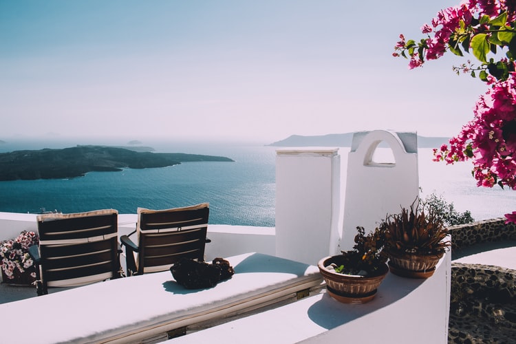 view over the ocean from a terrace in santorini, flowers on greece islands