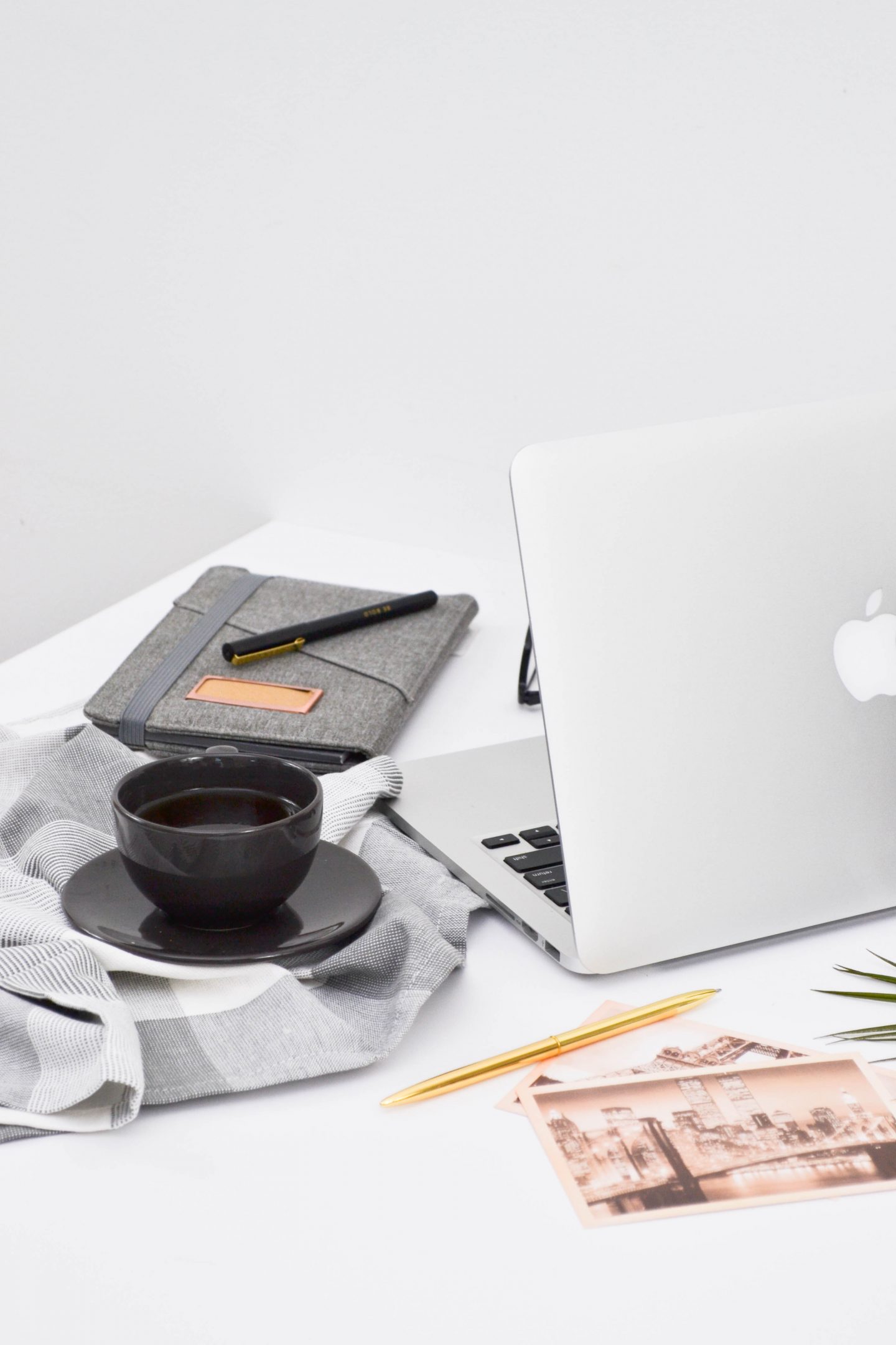 a laptop with a notebook, coffee and pictures of paris