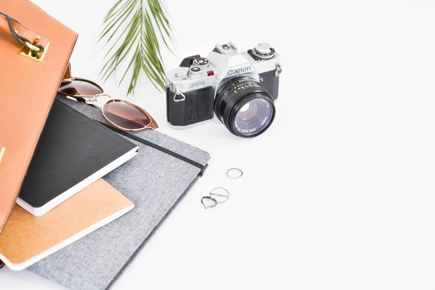 a camera with a tablet, earrings, sunglasses and notebooks