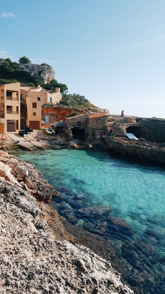 reasons to visit mallorca, ocean with village next to it