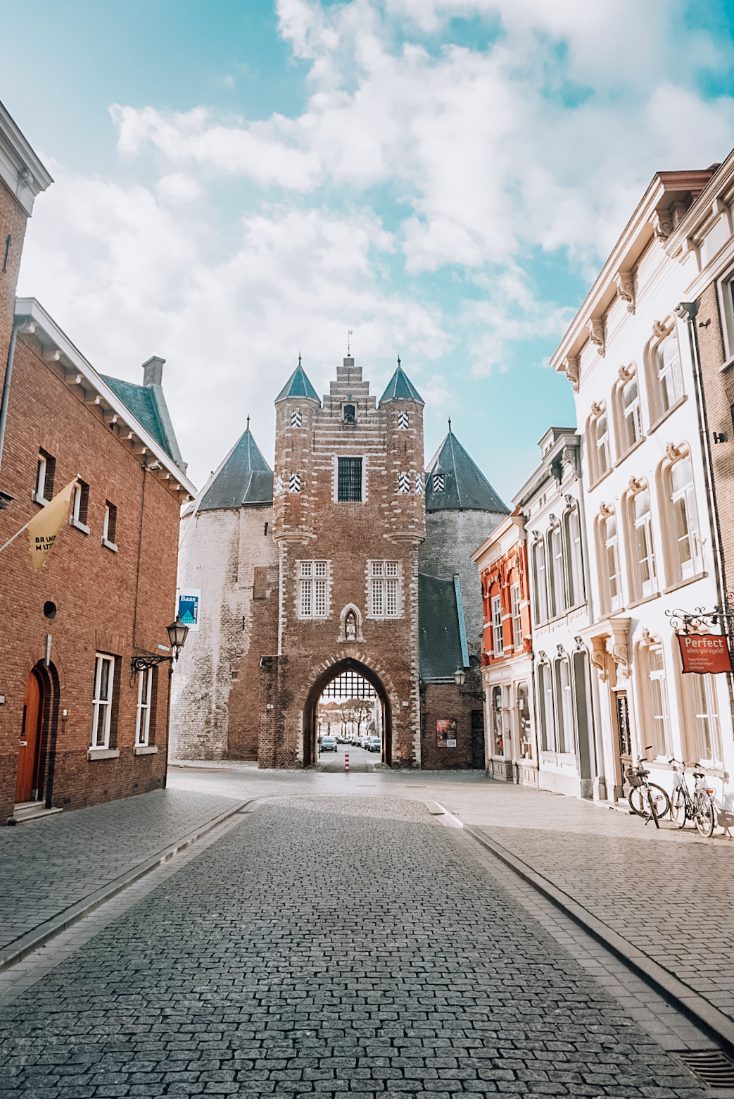 a historic gate in the city bergen op zoom in the netherlands, travel in holland, blue sky with houses