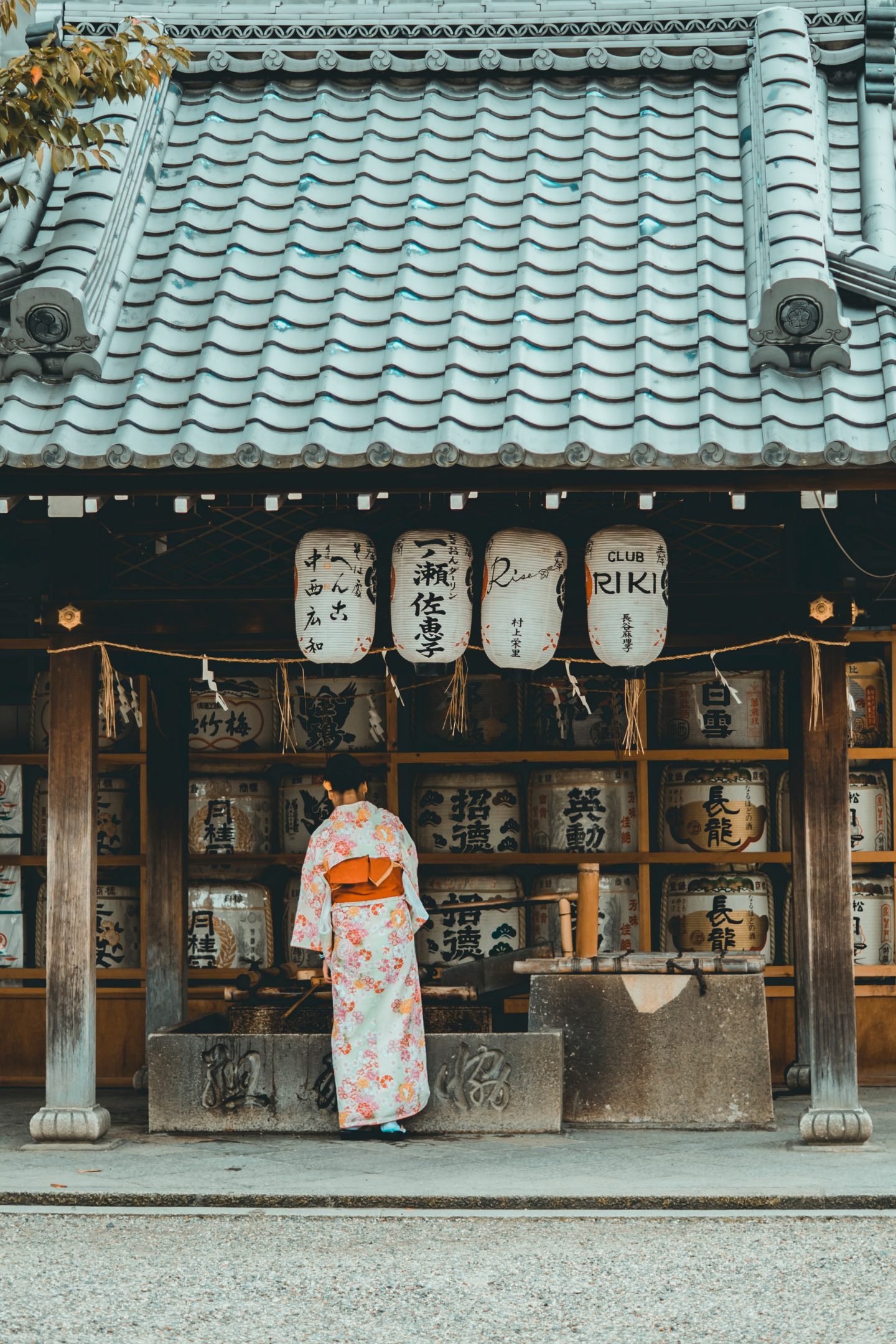 a woman in the front of a shop in asia with traditional clothes on