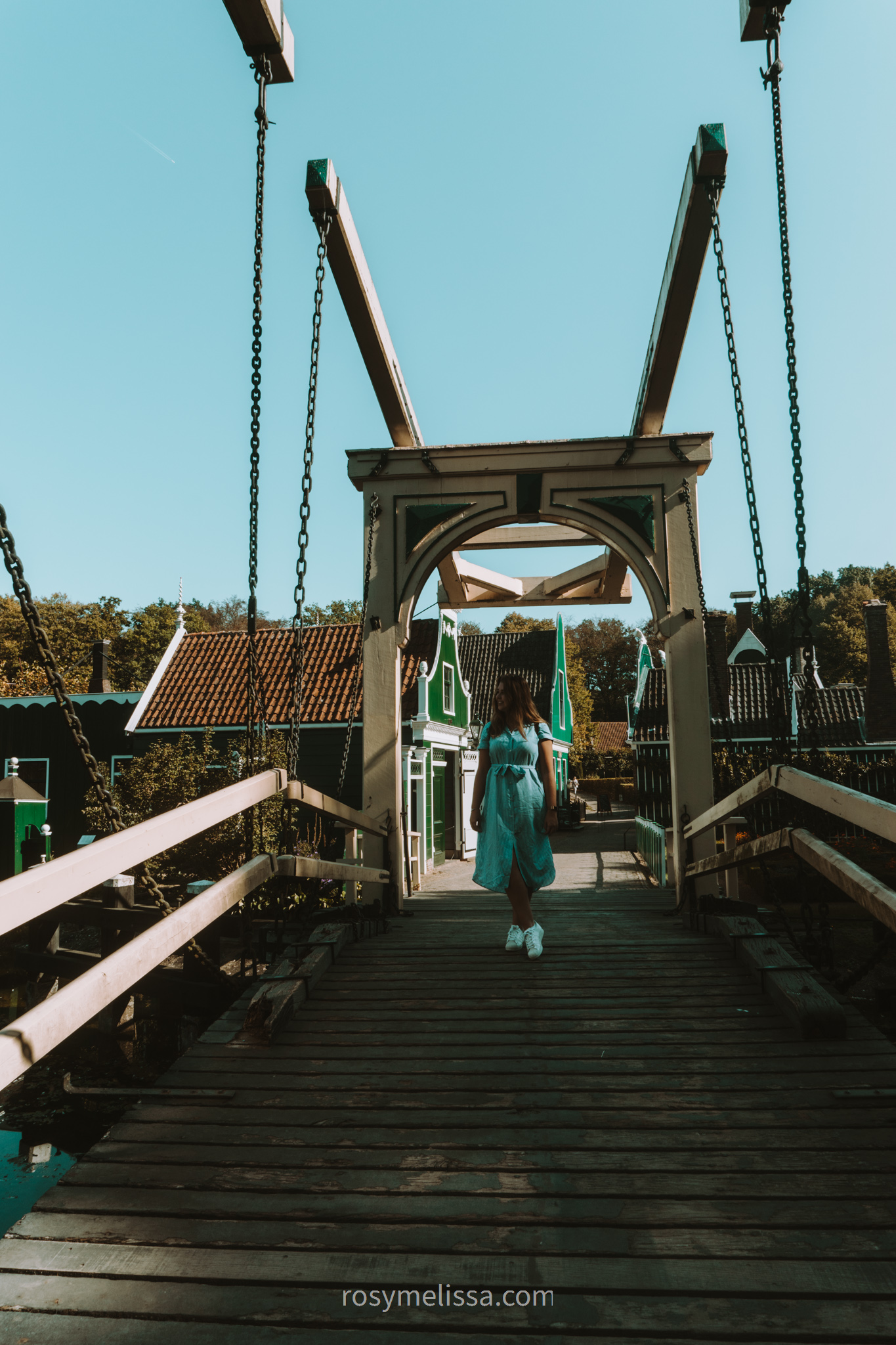 girl on a bridge with typical dutch houses in the background